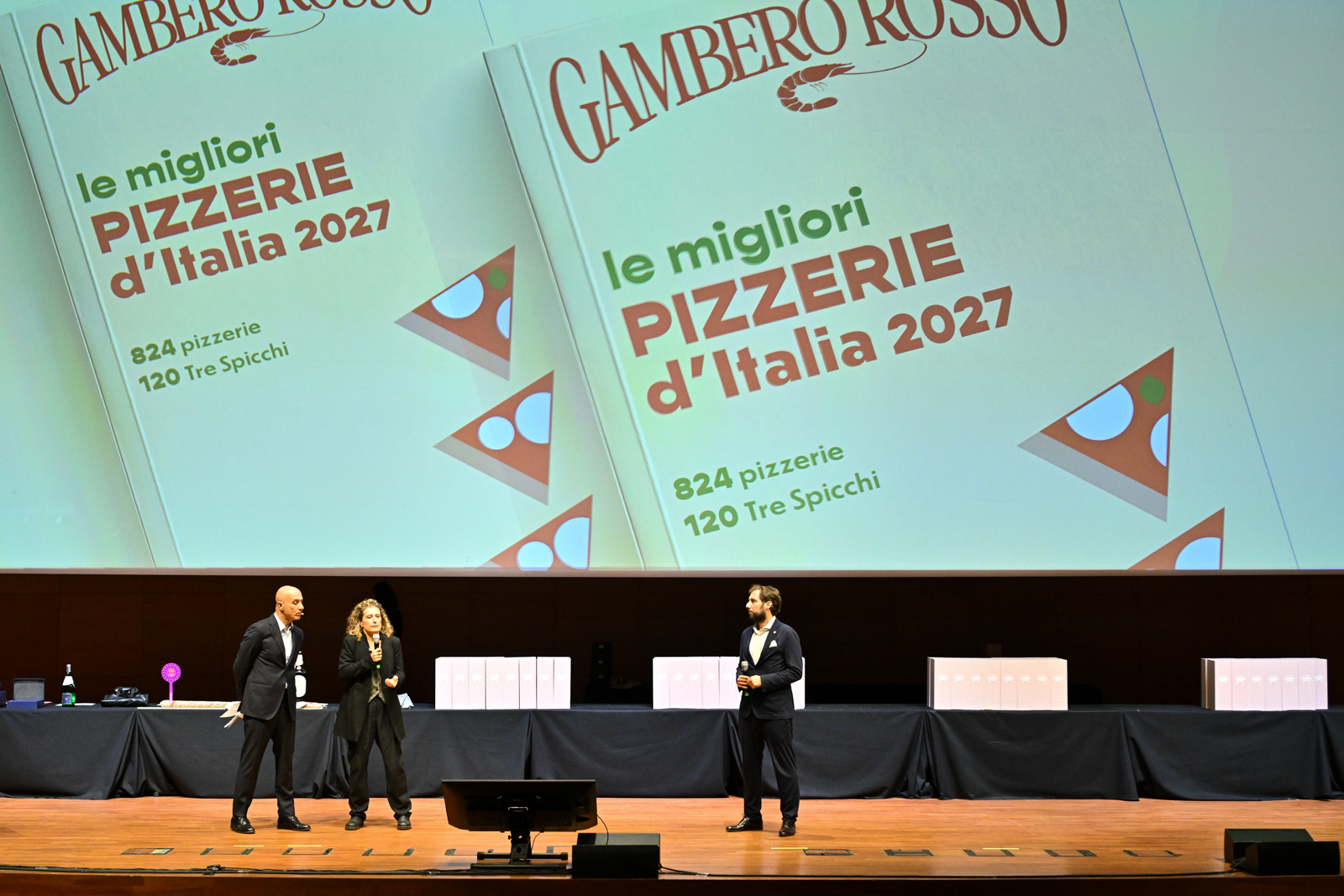 The Pizzerie d’Italia 2027 launch: the stage and the guide cover.