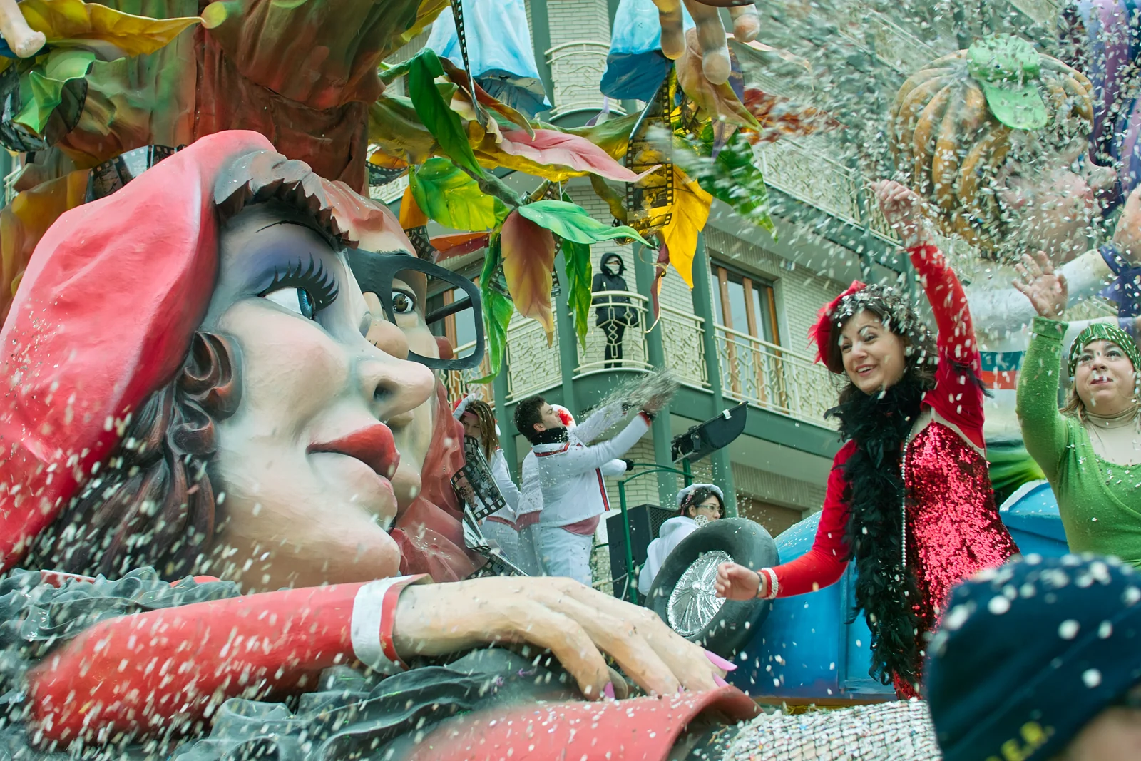 A papier-mâché float at the Putignano Carnival parade, with performers throwing confetti