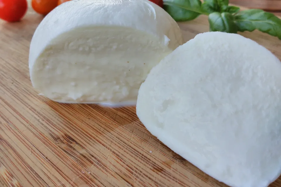 Sliced buffalo mozzarella with cherry tomatoes and basil, illustrative photograph