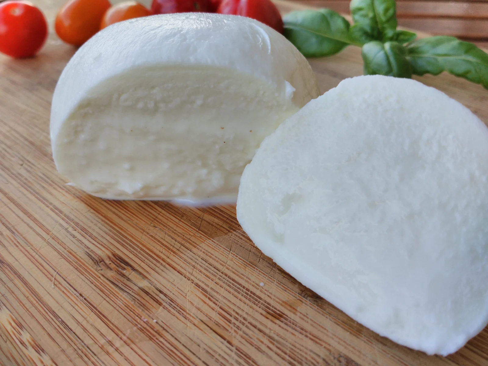 Sliced buffalo mozzarella with cherry tomatoes and basil, illustrative photograph