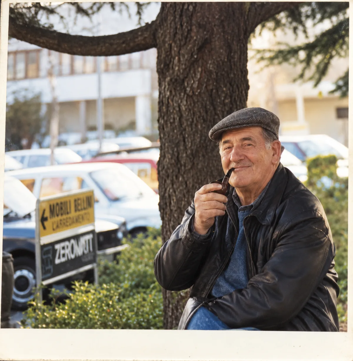 My grandfather Sebastiano in middle age, with his flat cap and pipe, sitting under a tree.